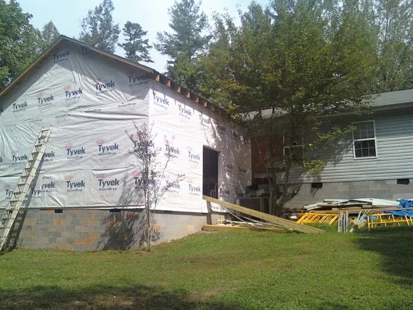 Tyvek wrapped gable on a new room addition beside an existing home in Liscomb